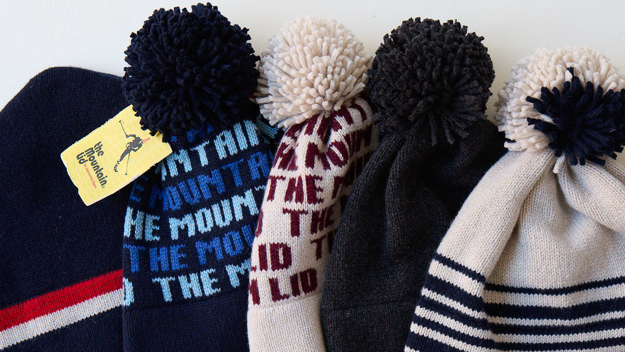 Collection of beanies with pom-poms and text on a white background
