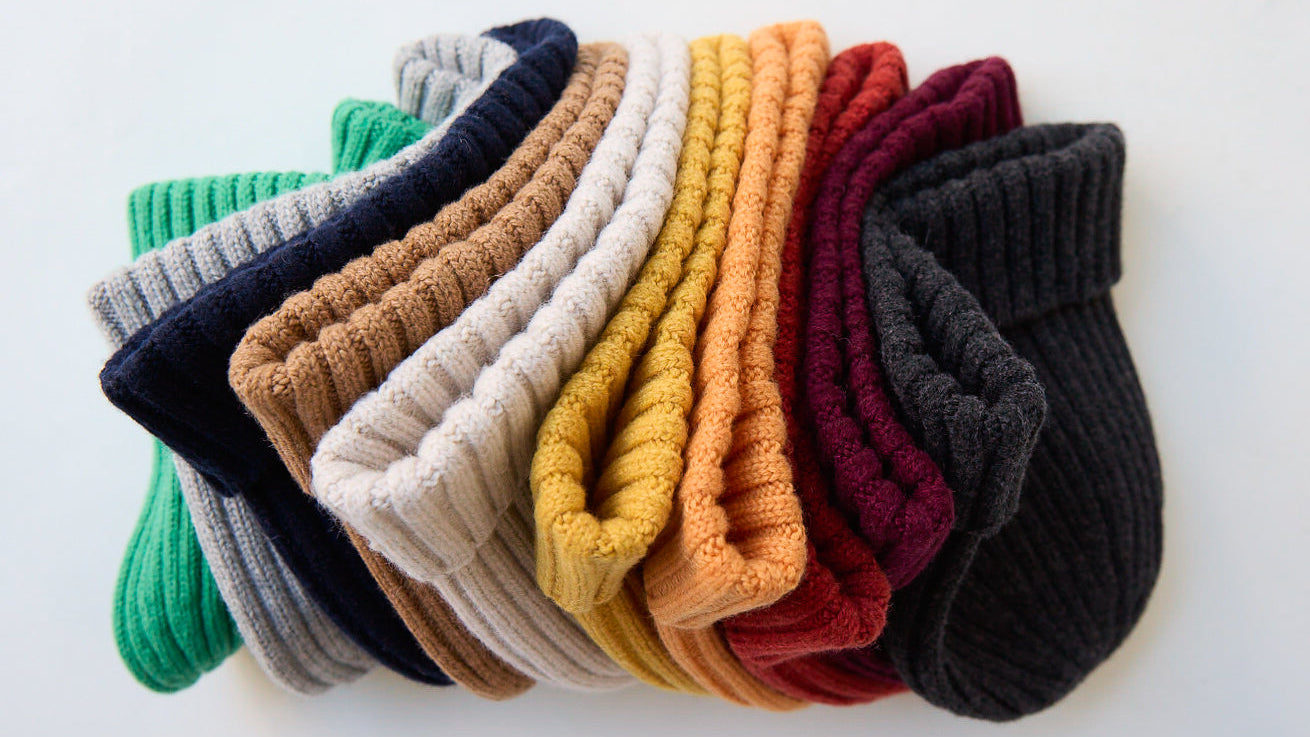 Set of colorful beanies arranged in a circular pattern on a light background